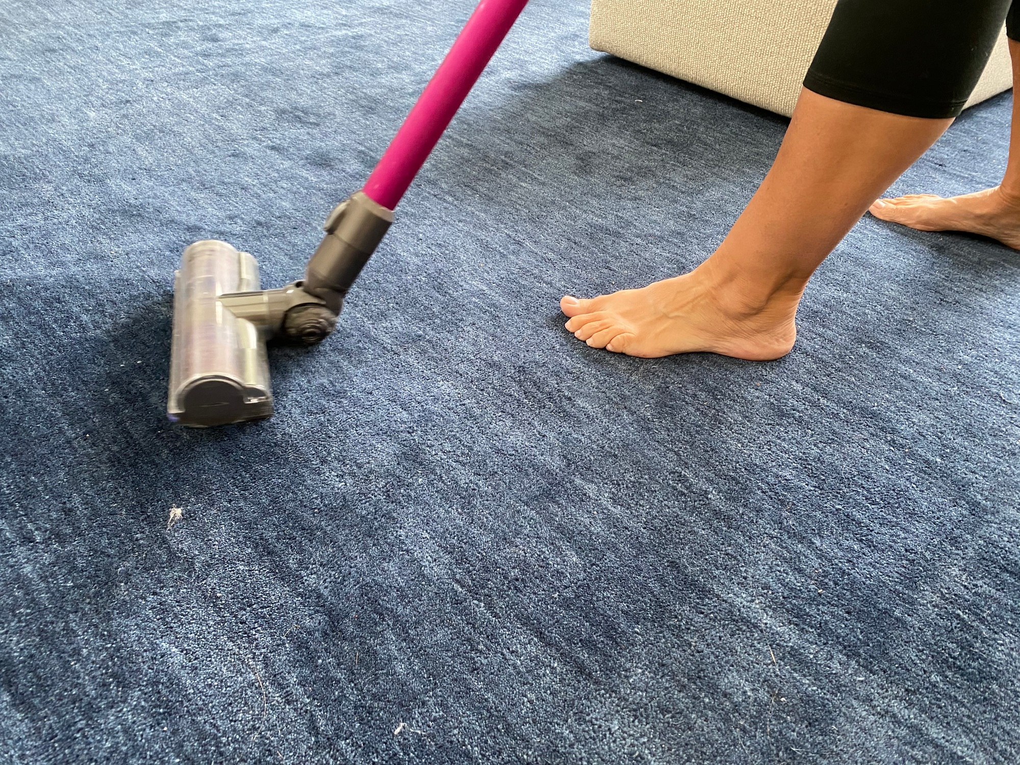 Vacuuming the blue carpet with the pink vacuum cleaner
