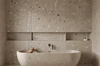Grande dalle murale en grès cérame effet terrazzo greige dans une salle de bain contemporaine avec baignoire îlot